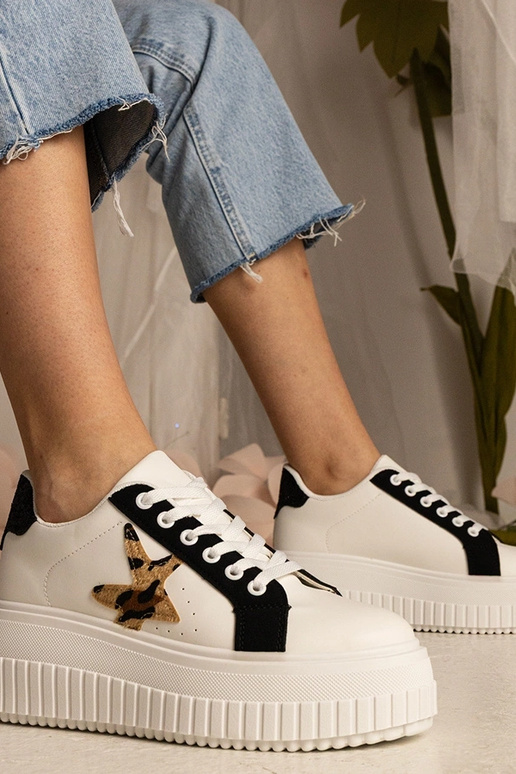 Sneakers bianchi e neri decorate con...