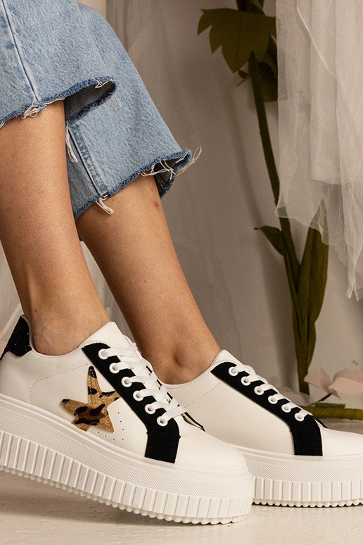 Sneakers bianchi e neri decorate con...