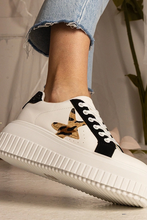 Sneakers bianchi e neri decorate con...