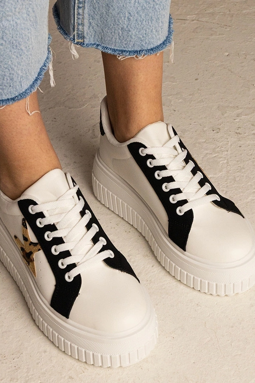 Sneakers bianchi e neri decorate con...